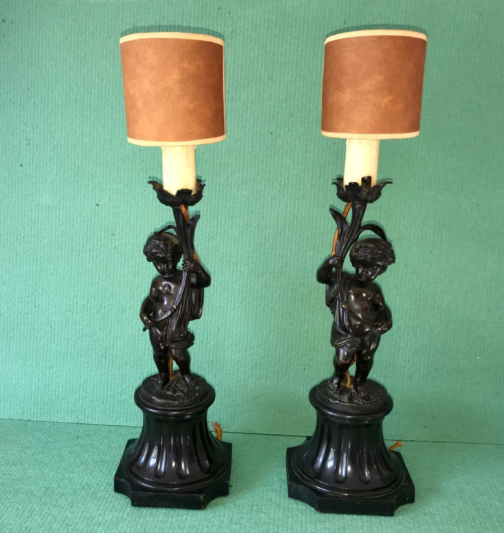 A  Pair of bronze cherub lamps 