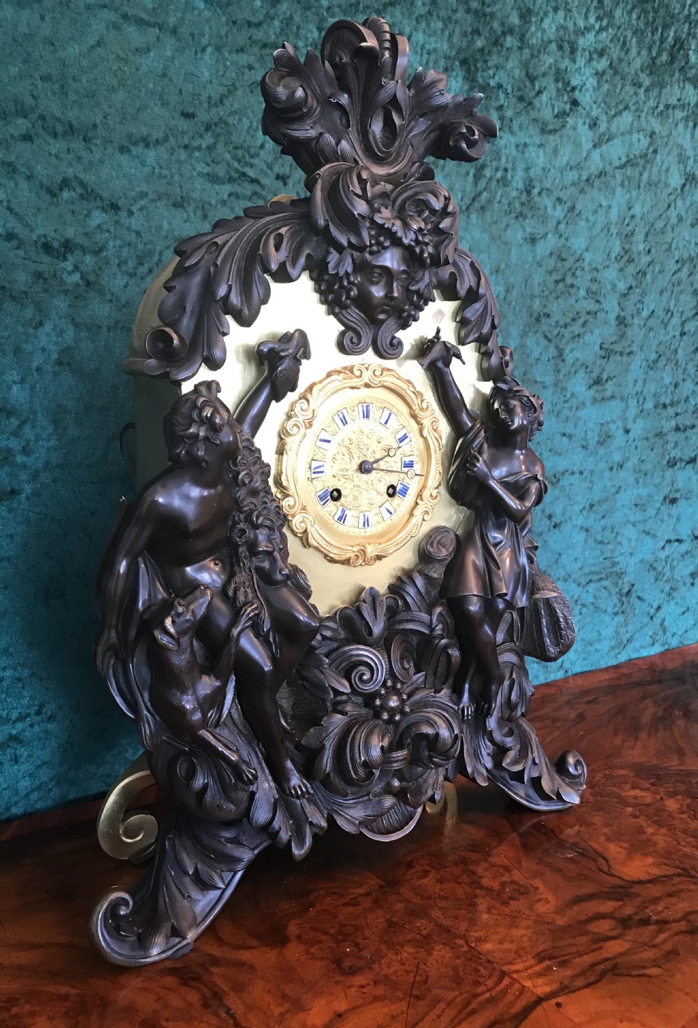 A Victorian patinated bronze mantel clock featuring classical figural sculptures, scrollwork ornamentation, and a gilt dial with enamel Roman numerals. View III