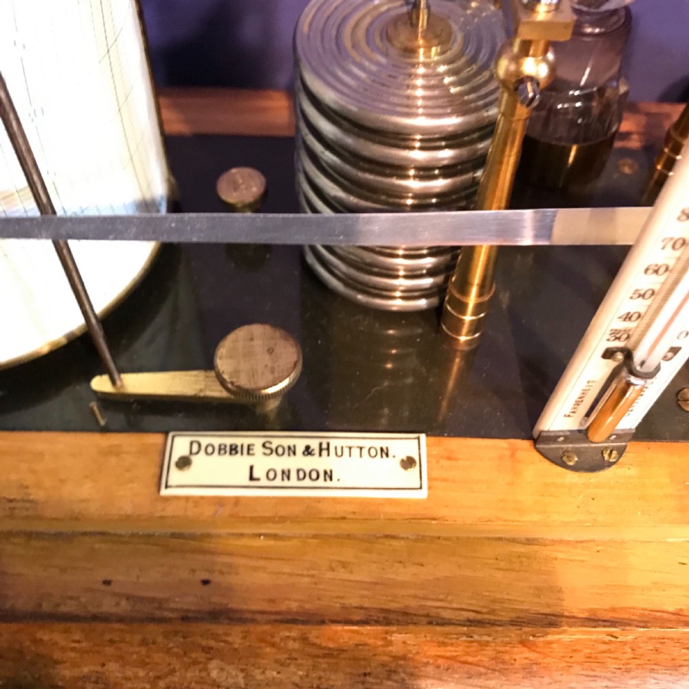 An antique barograph with a brass mechanism and paper recording drum encased in a glazed oak frame topped with a brass handle. View IV