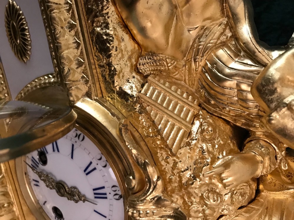A French late 19th-century gilt bronze and white marble mantel clock topped with sculptures of a seated couple, featuring an enamel dial with Roman numerals. View V