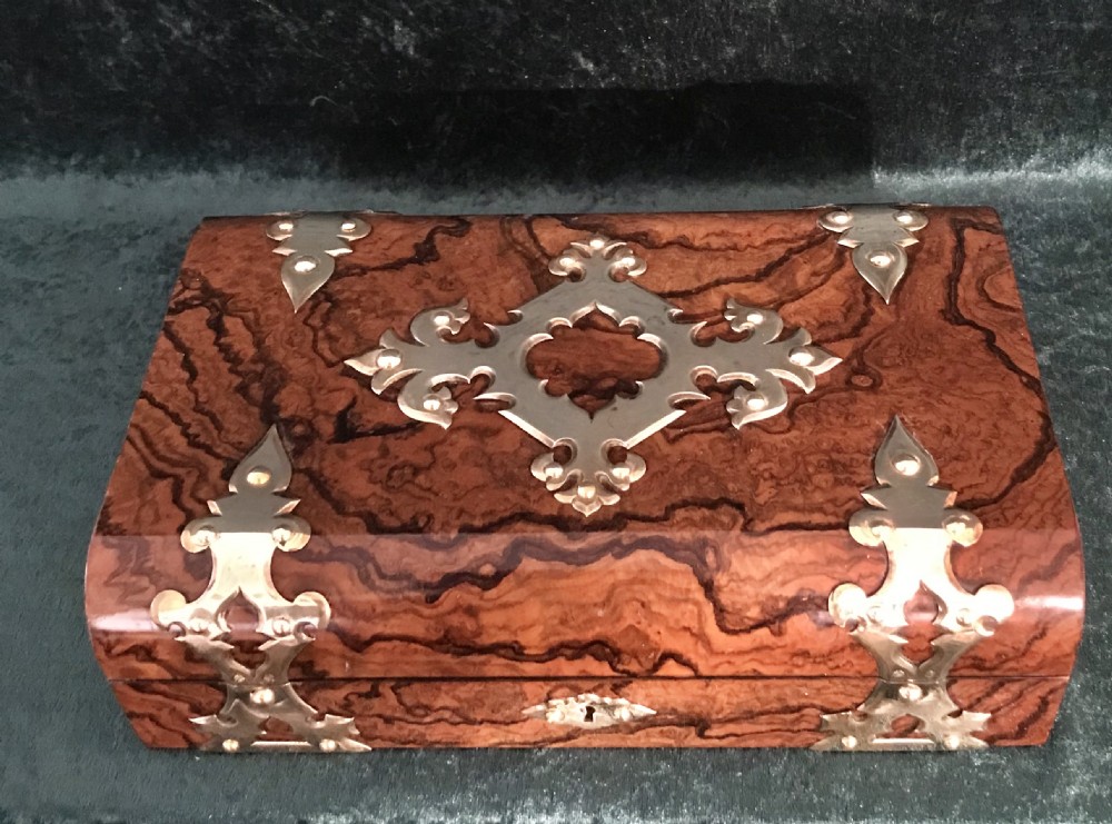 An open Victorian burr walnut games box with brass corner mounts, revealing a silk-lined lid with scoring boards and red fitted compartments filled with card registers and gaming counters. View VII