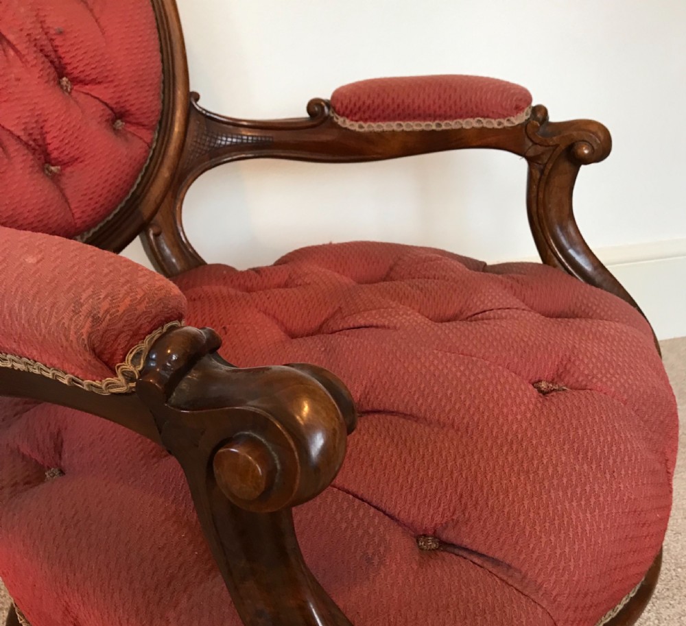 A pair of mid-Victorian walnut chairs upholstered in deep-buttoned red fabric with oval backrests and cabriole legs. View V