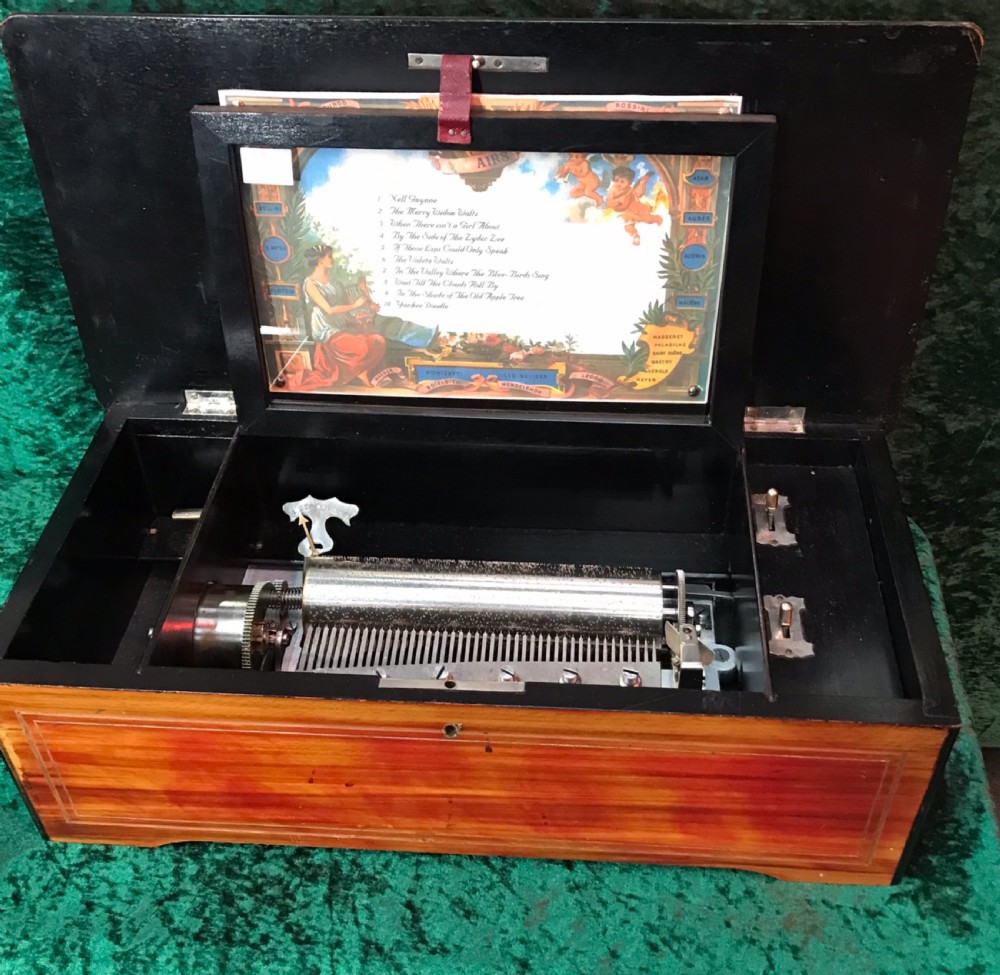 A rectangular Victorian wooden music box featuring floral marquetry inlay on the lid and ebonised border moulding. View VI
