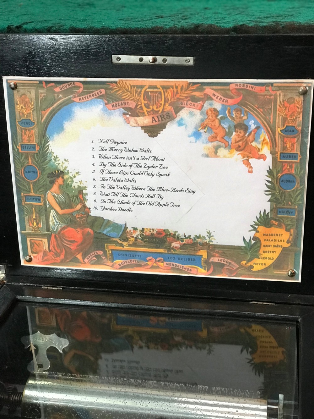 A rectangular Victorian wooden music box featuring floral marquetry inlay on the lid and ebonised border moulding. View VII