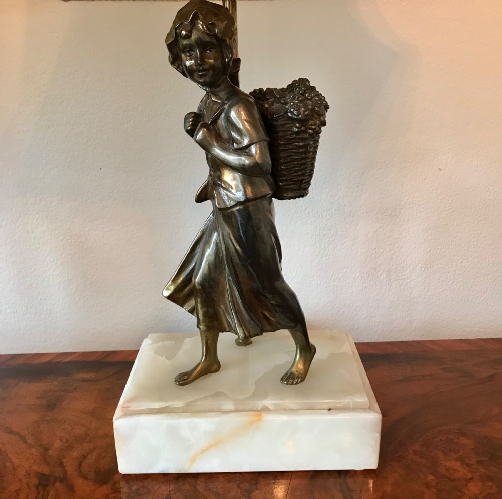 A pair of 1930s Art Deco table lamps featuring bronze figures of a boy and girl standing on rectangular onyx bases beneath flared cream shades. View III