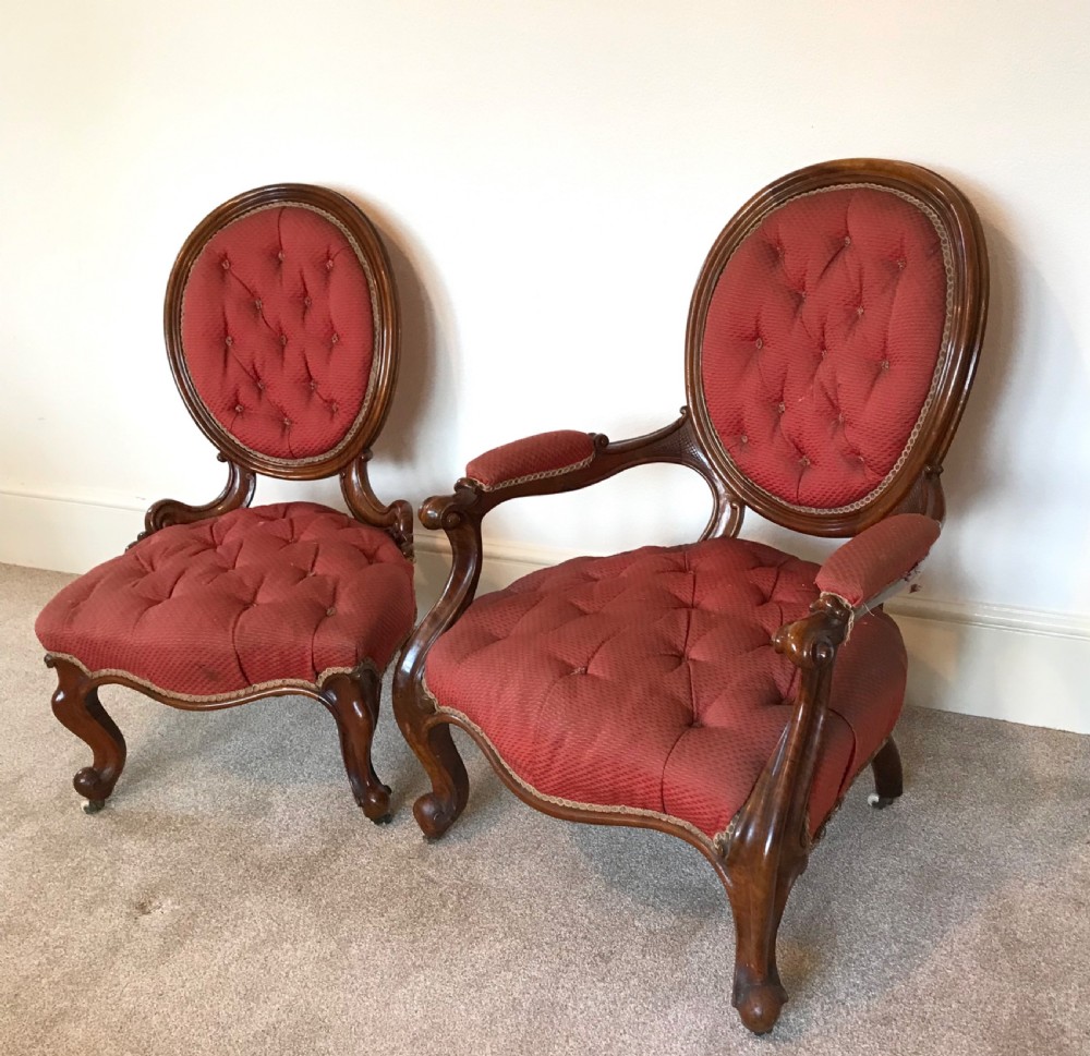 A pair of Victorian timber salon chairs featuring deep-buttoned terracotta upholstery, carved oval backs, and cabriole legs on castors. View IV
