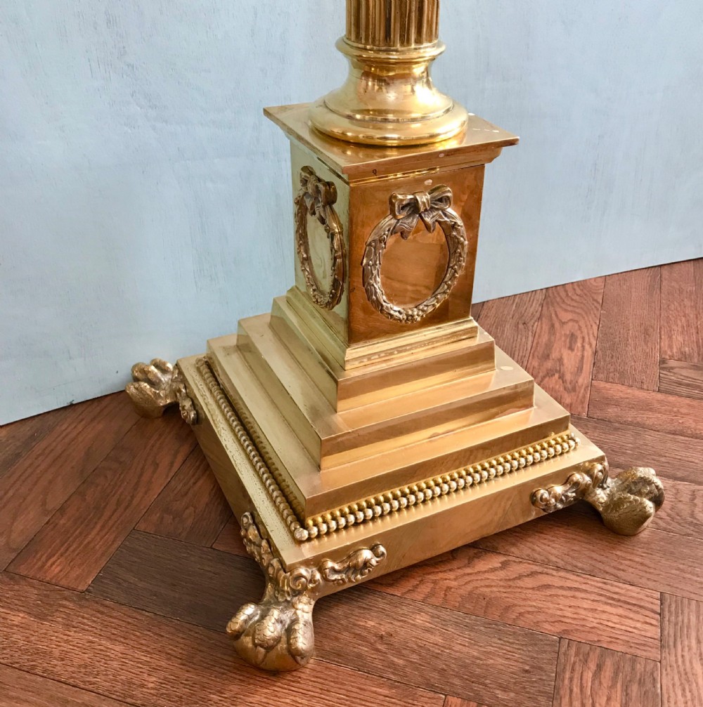 A tall Neoclassical style brass standard lamp featuring a fluted Corinthian column on a square plinth base with paw feet and a dark navy drum shade. View VI