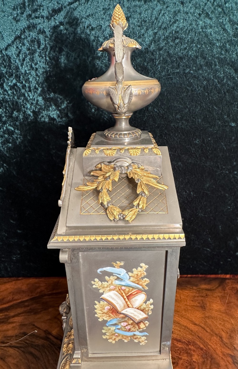 A 19th-century French mantel clock featuring a grey painted metal case decorated with gilded mounts and hand-painted porcelain panels topped with an urn finial. View III