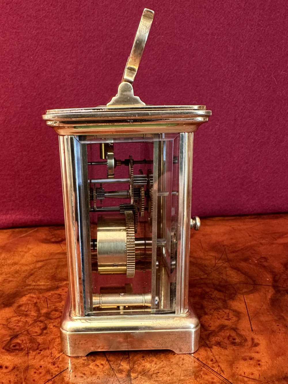 A brass carriage clock featuring bevelled glass panels, a white dial signed Garrard and Co London W1 with Roman numerals, and a hinged top handle. View VI