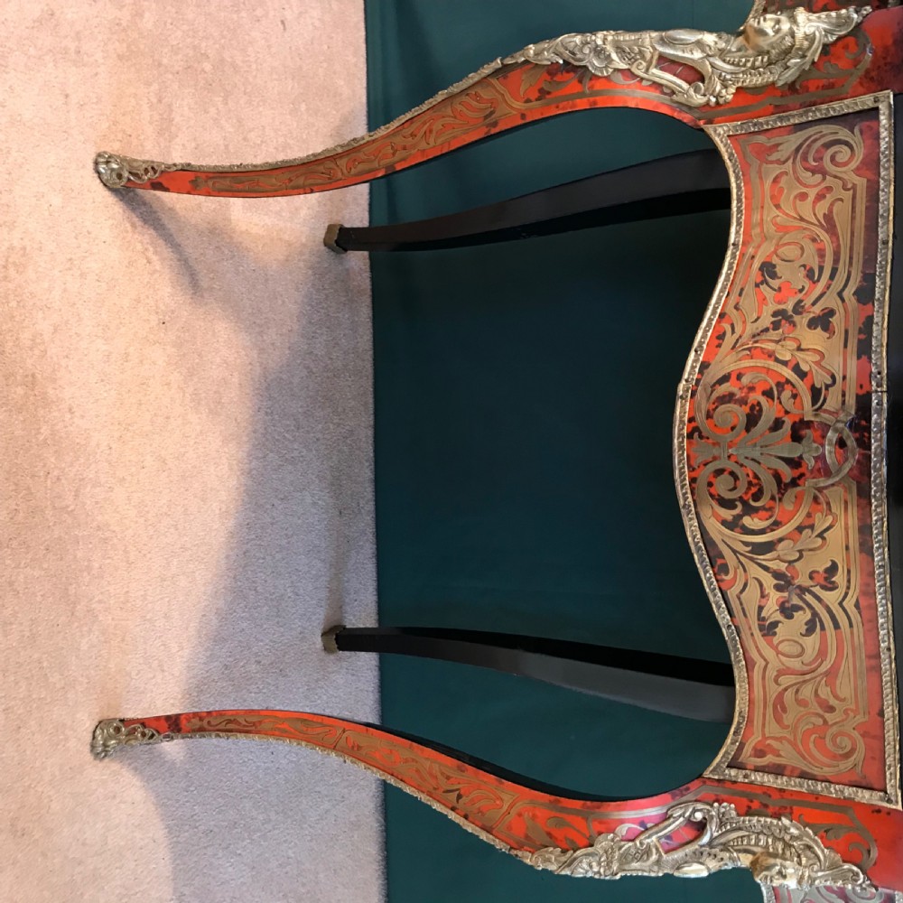 A French Napoleon III serpentine centre table decorated with red tortoiseshell and brass Boulle marquetry inlay, gilt-bronze mounts, and cabriole legs. View VI