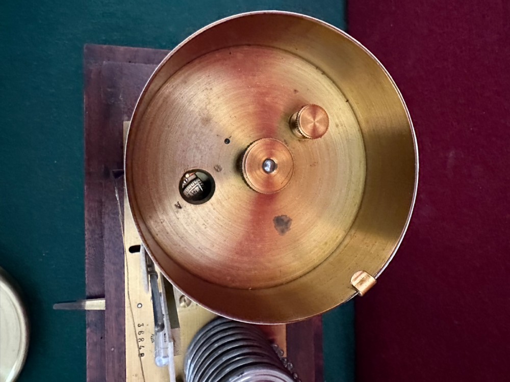 An early 20th-century Jules Richard barograph housed in a glazed oak case with a carrying handle, featuring internal brass mechanisms, a paper recording drum, and a thermometer. View V