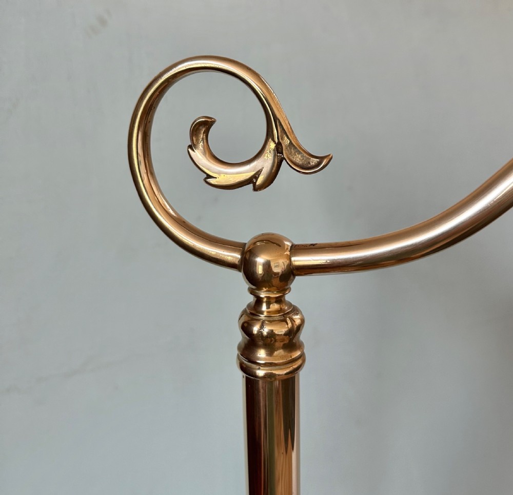 A pair of circa 1920 brass standard lamps featuring scrolled swan-neck arms, ornate cast bases, and scalloped domed lampshades. View VI