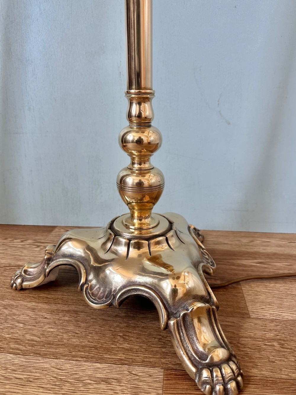 A pair of circa 1920 brass standard lamps featuring scrolled swan-neck arms, ornate cast bases, and scalloped domed lampshades. View VII