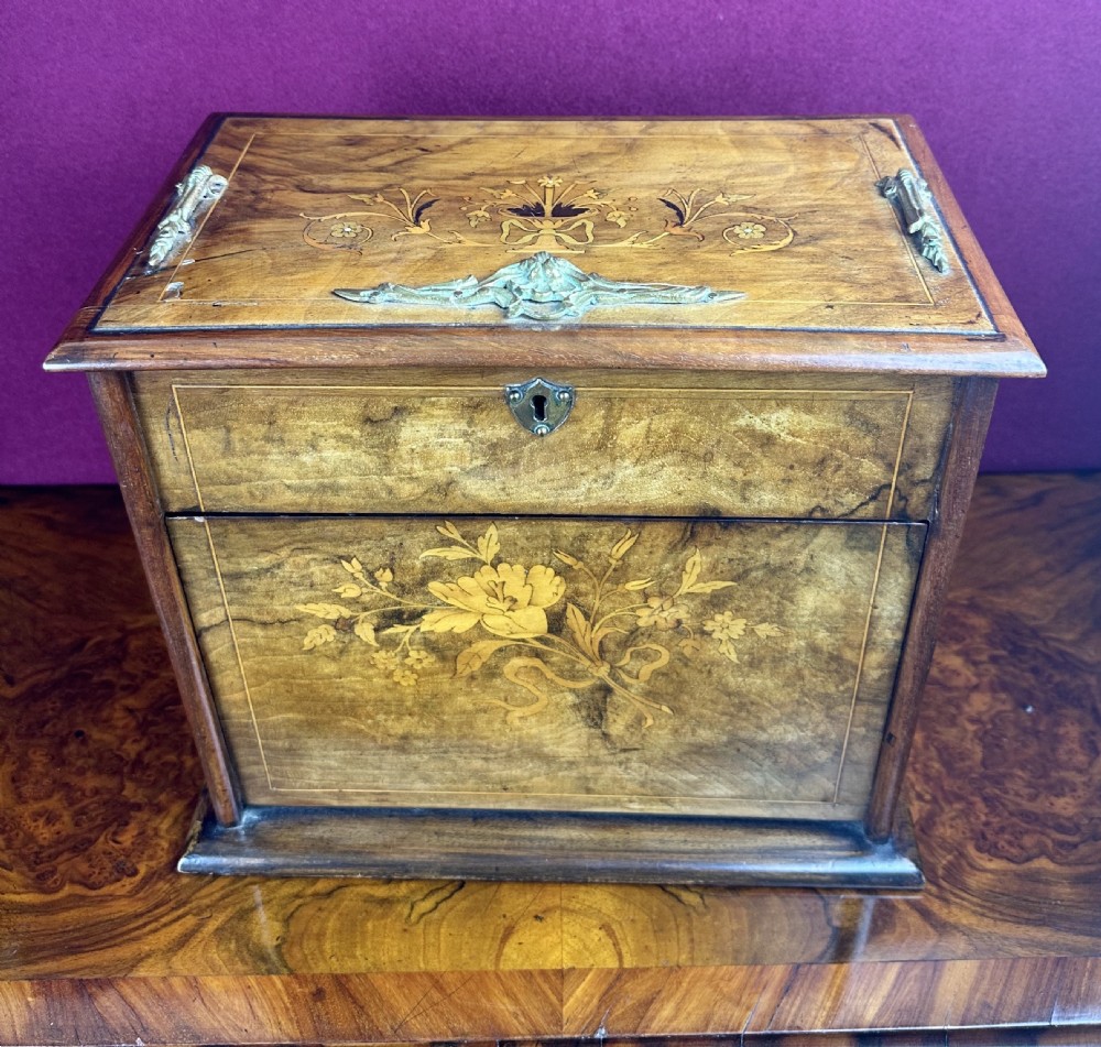 An Edwardian warm brown wooden stationery cabinet decorated with floral marquetry inlay and fitted with a brass keyhole escutcheon. View III