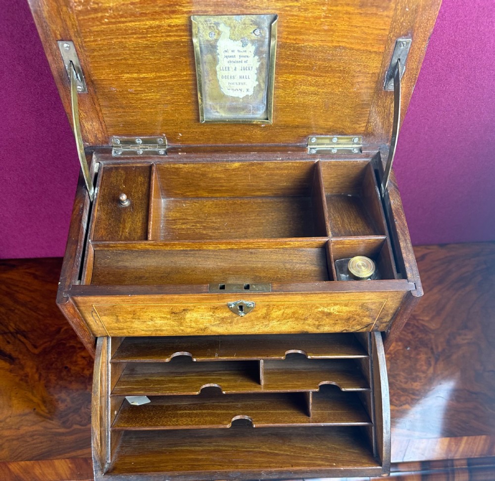 An Edwardian warm brown wooden stationery cabinet decorated with floral marquetry inlay and fitted with a brass keyhole escutcheon. View V