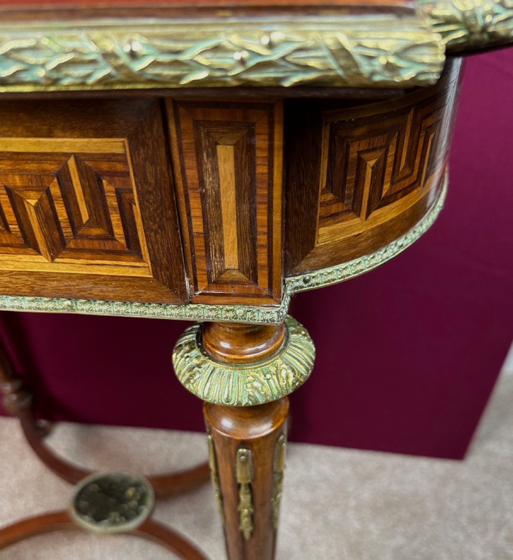 A late 19th-century French Louis XVI style marquetry poudreuse table featuring floral marquetry inlay, Greek key frieze, ormolu mounts, and fluted tapered legs. View IV