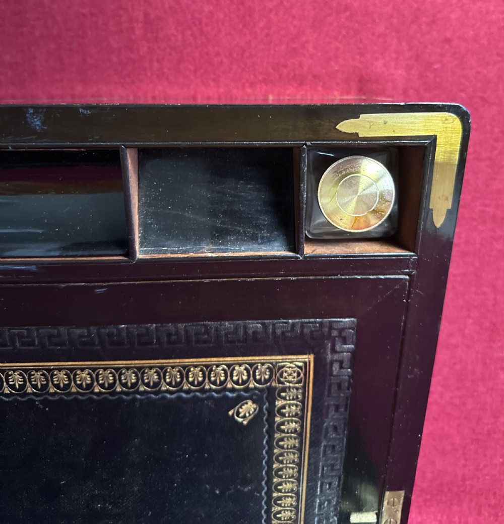 A dark rosewood campaign correspondence box featuring brass edge trim, a central rectangular brass nameplate, and a key inserted into the brass keyhole escutcheon. View V
