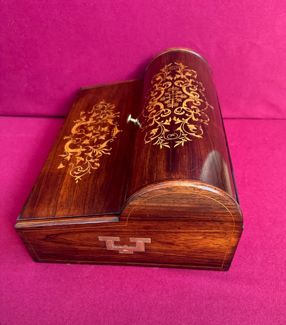 A Victorian dark rosewood writing slope box featuring delicate floral marquetry inlay, side brass handles, and a key with a tassel. View II