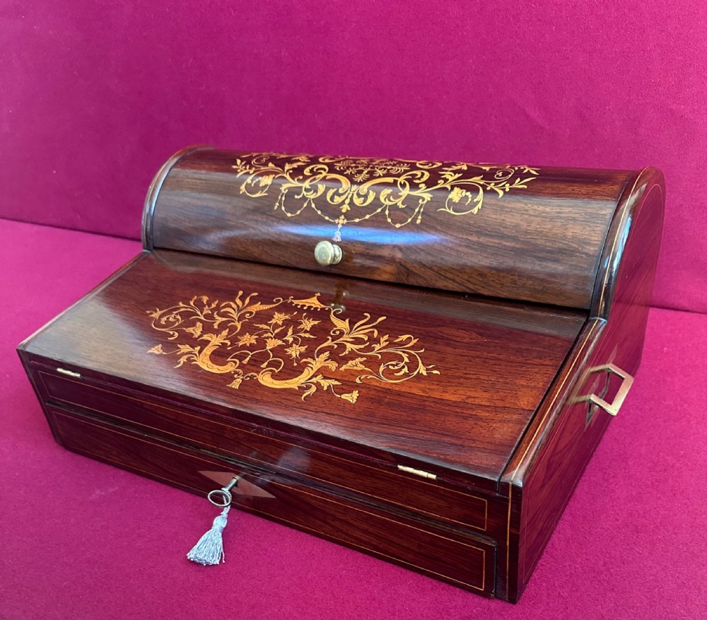 A Victorian dark rosewood writing slope box featuring delicate floral marquetry inlay, side brass handles, and a key with a tassel. View VIII