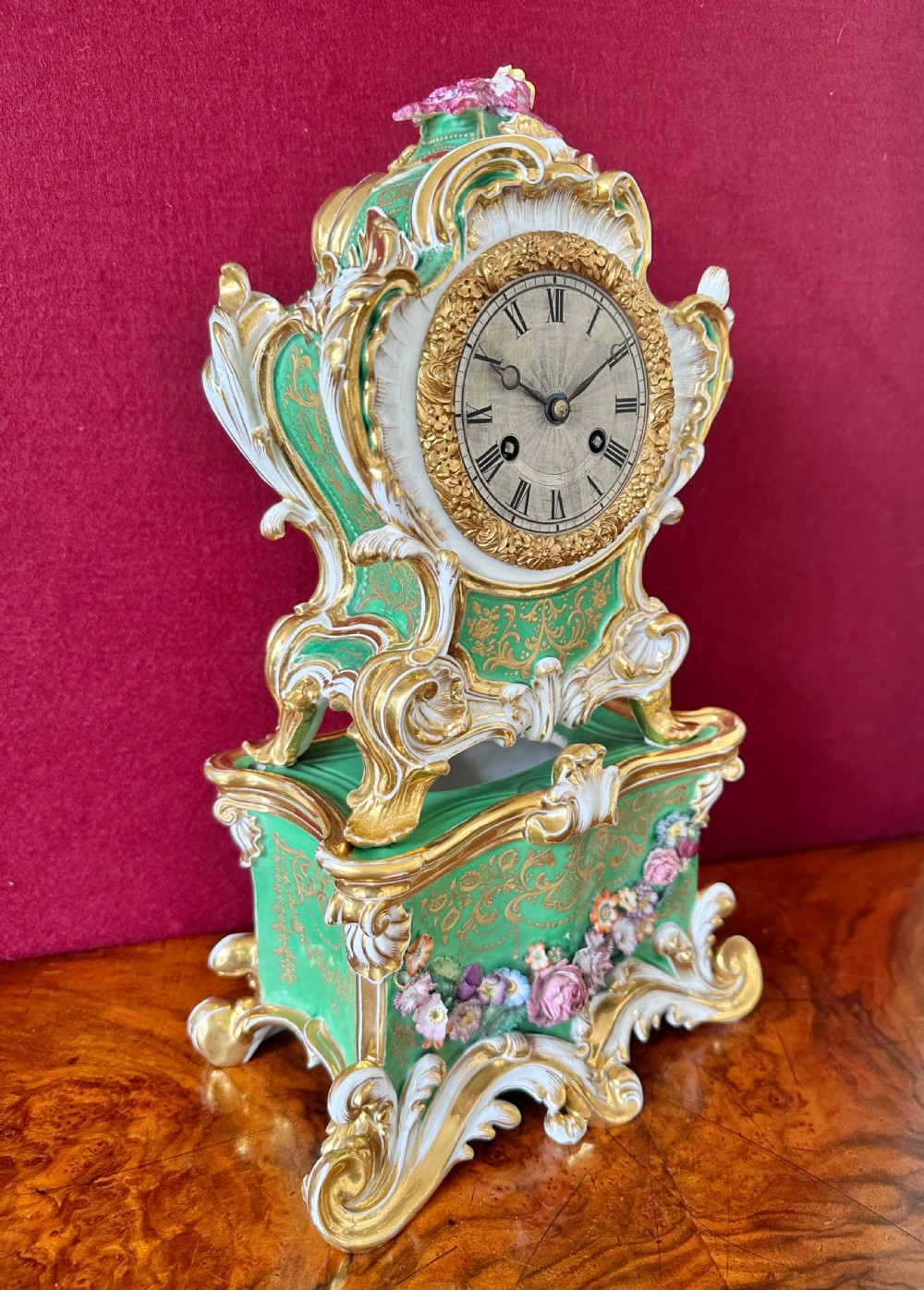 An early 19th-century French Rococo Revival porcelain mantel clock featuring green glaze, gilt scrollwork, and hand-moulded floral details. View III