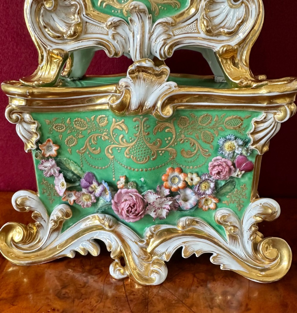 An early 19th-century French Rococo Revival porcelain mantel clock featuring green glaze, gilt scrollwork, and hand-moulded floral details. View VI