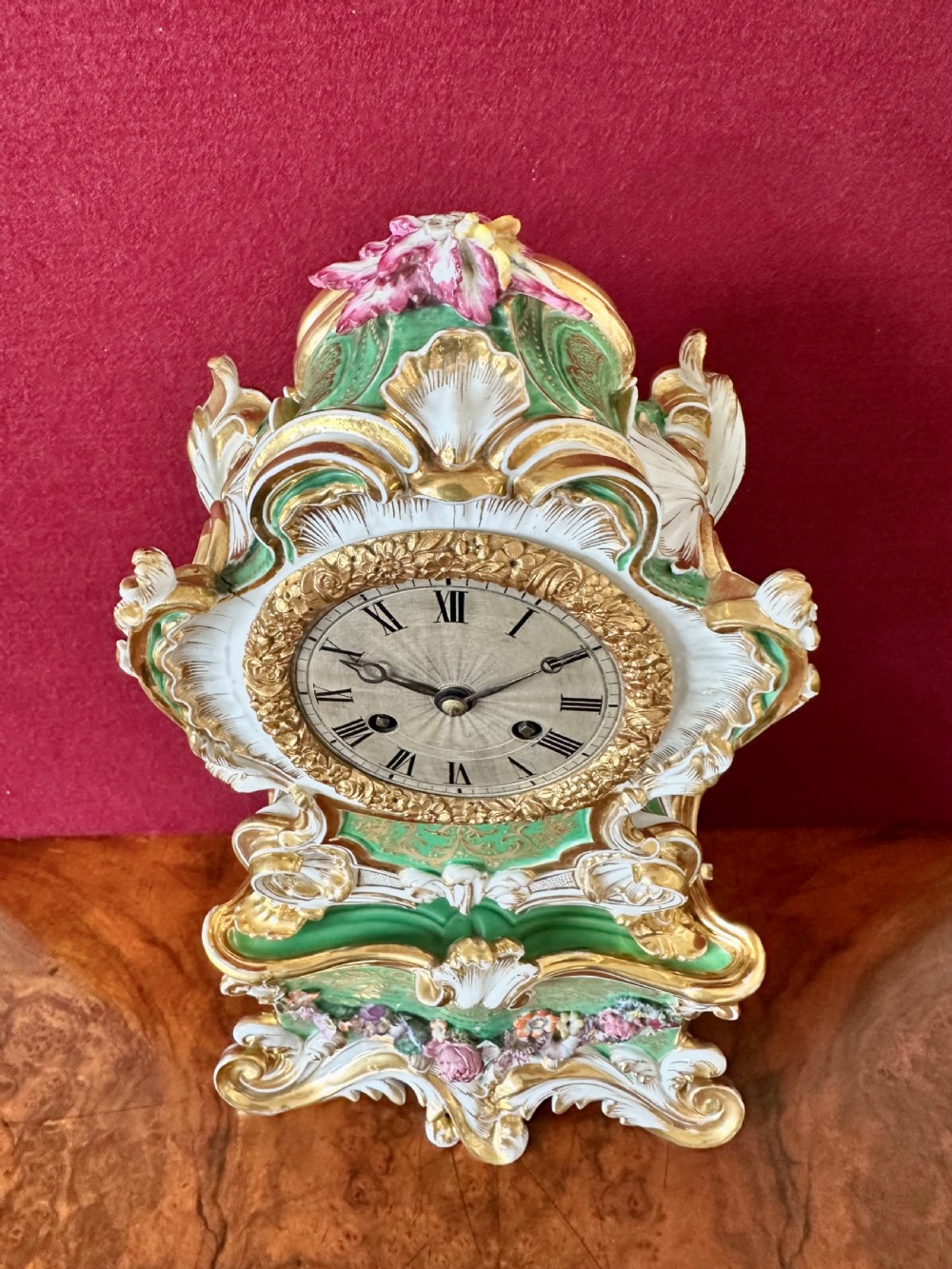 An early 19th-century French Rococo Revival porcelain mantel clock featuring green glaze, gilt scrollwork, and hand-moulded floral details. View VII