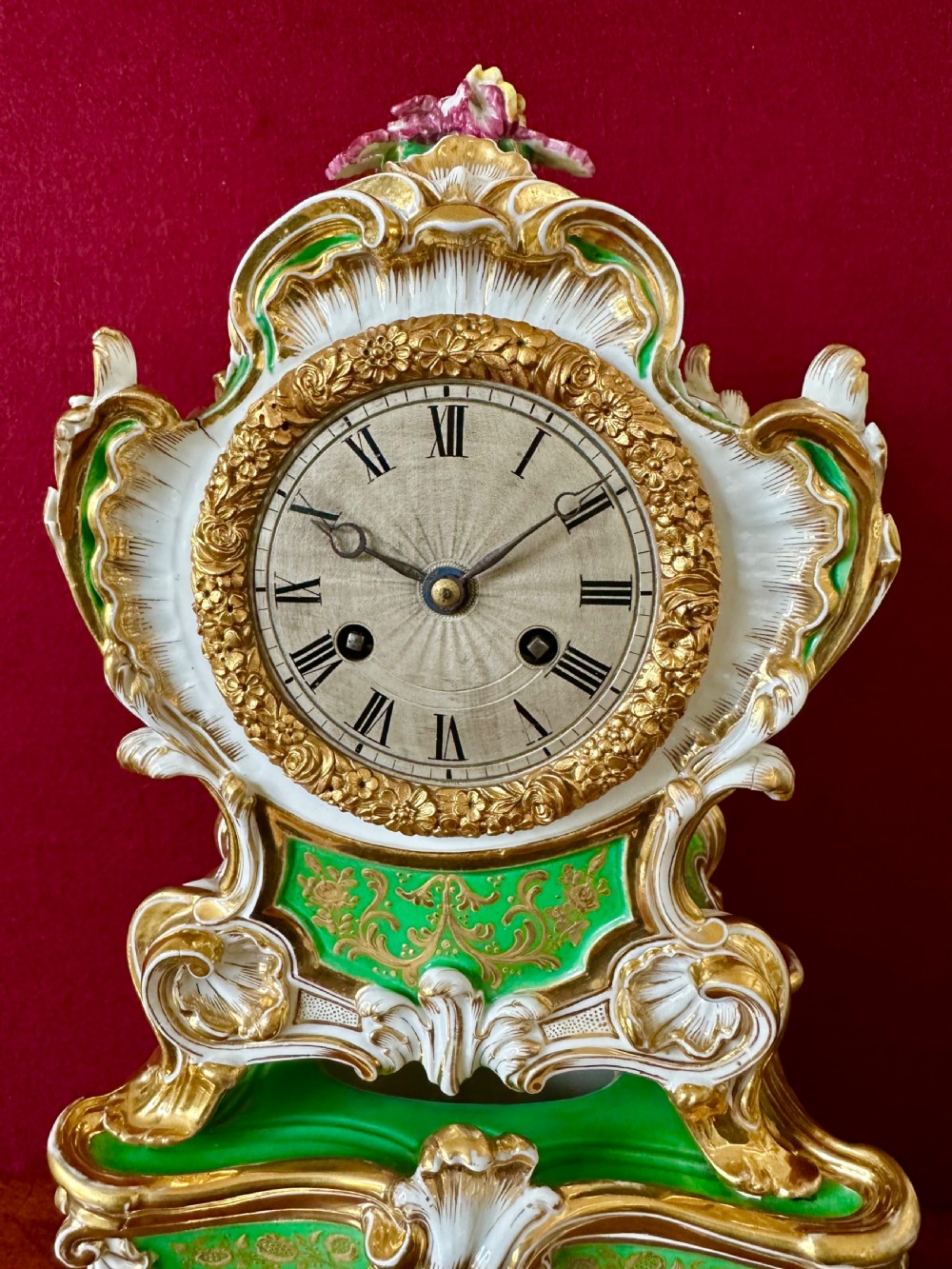 An early 19th-century French Rococo Revival porcelain mantel clock featuring green glaze, gilt scrollwork, and hand-moulded floral details. View IX