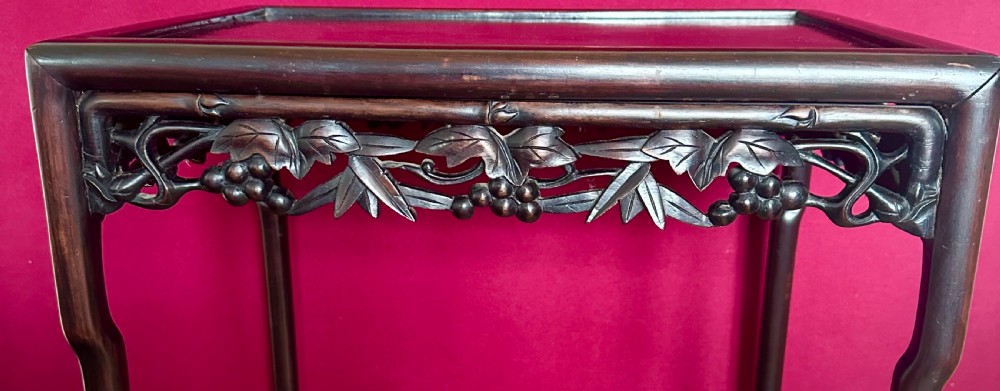 A set of four dark hardwood Chinese nesting tables featuring openwork carved bamboo aprons and faux-bamboo legs. View V