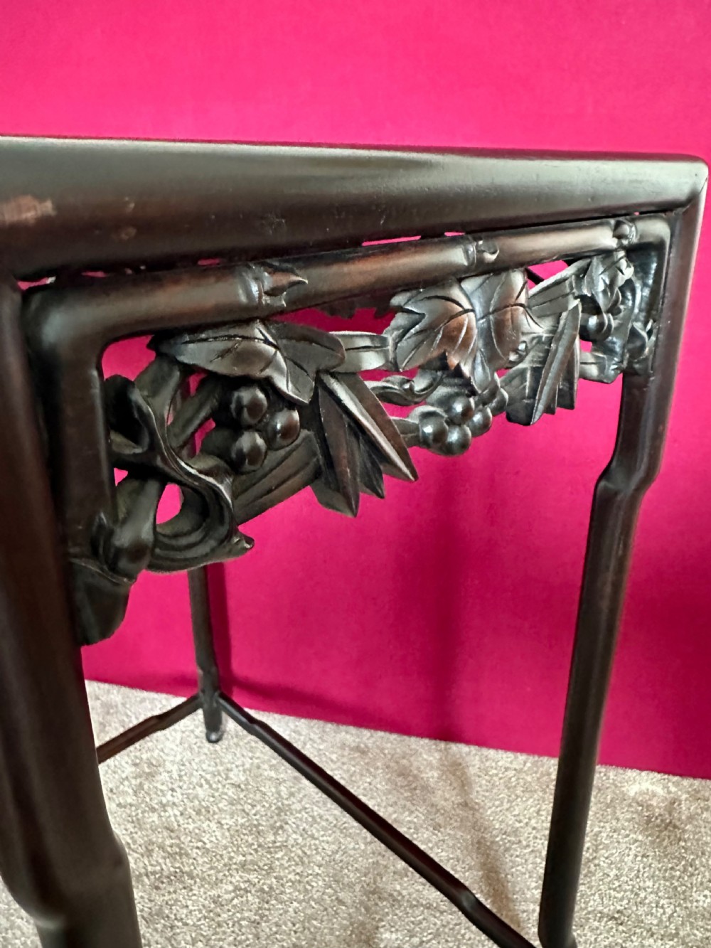 A set of four dark hardwood Chinese nesting tables featuring openwork carved bamboo aprons and faux-bamboo legs. View X