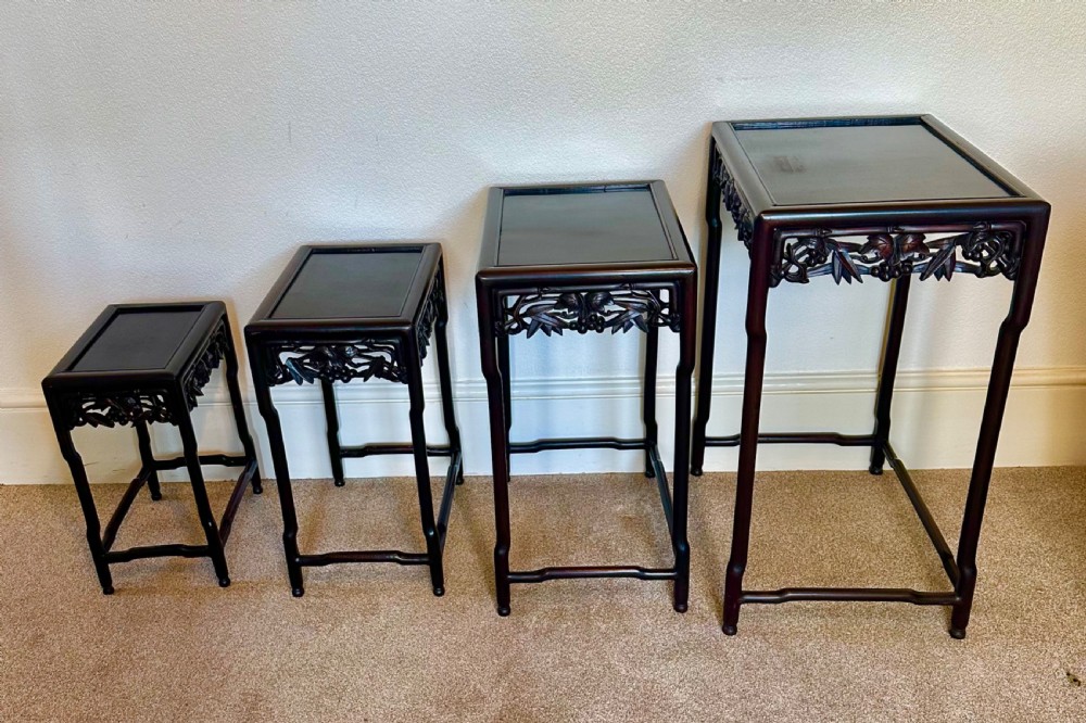A set of four dark hardwood Chinese nesting tables featuring openwork carved bamboo aprons and faux-bamboo legs. View XI
