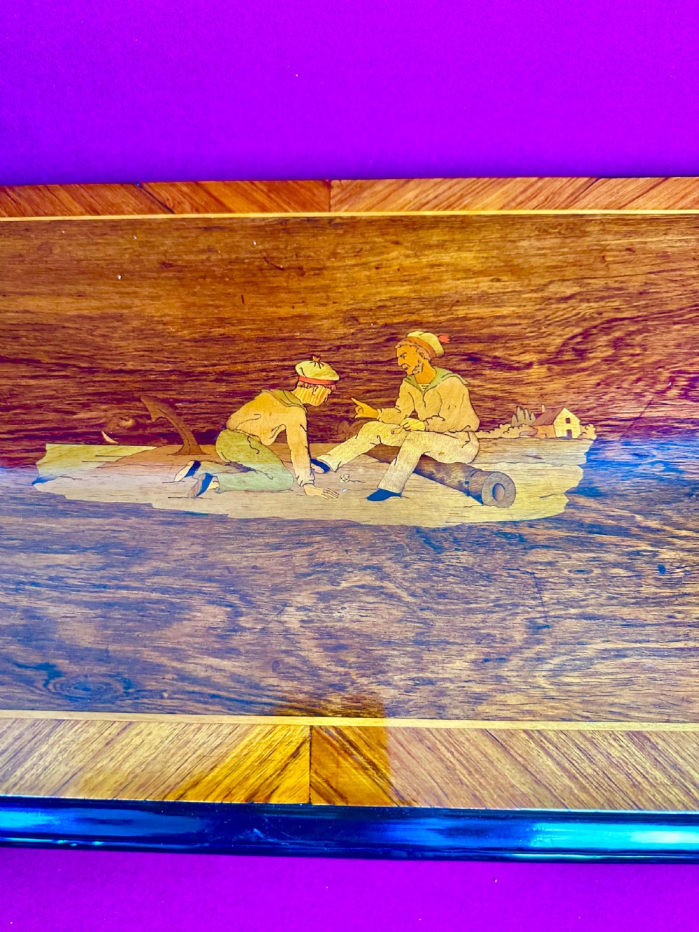A rectangular Victorian wooden music box featuring rich wood veneers, ebonised trim, and a central marquetry inlay depicting figures on the lid. View II