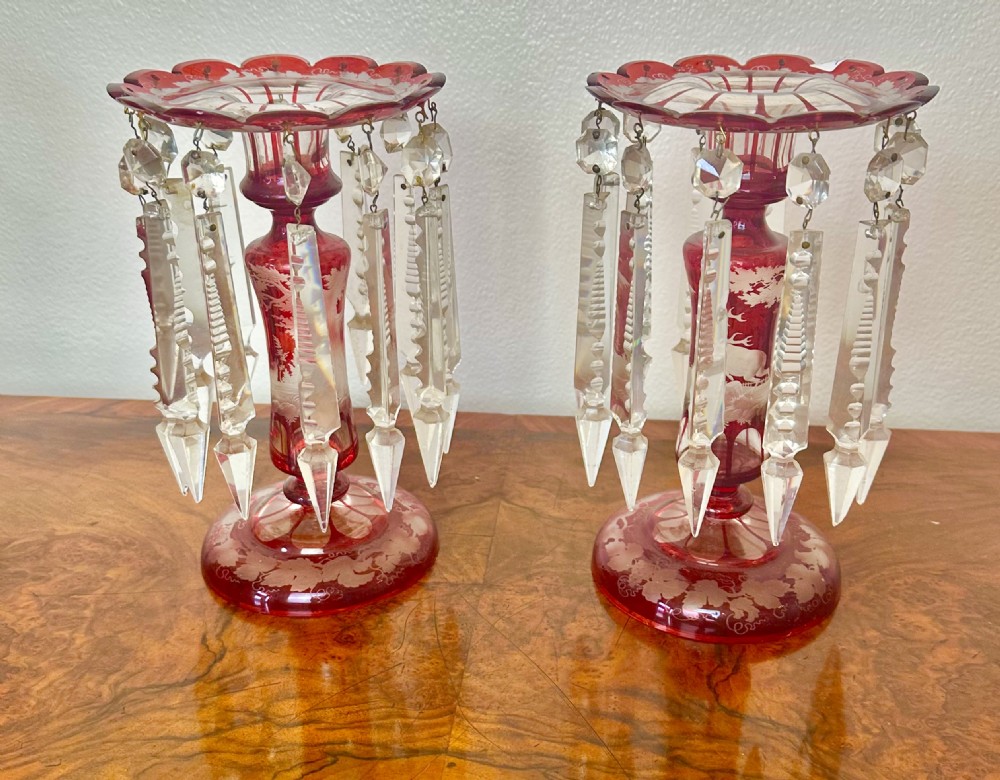 A pair of 19th-century Victorian ruby red flash glass lustres with acid-etched stag scenes, scalloped rims, and suspended clear crystal prism drops. View VII