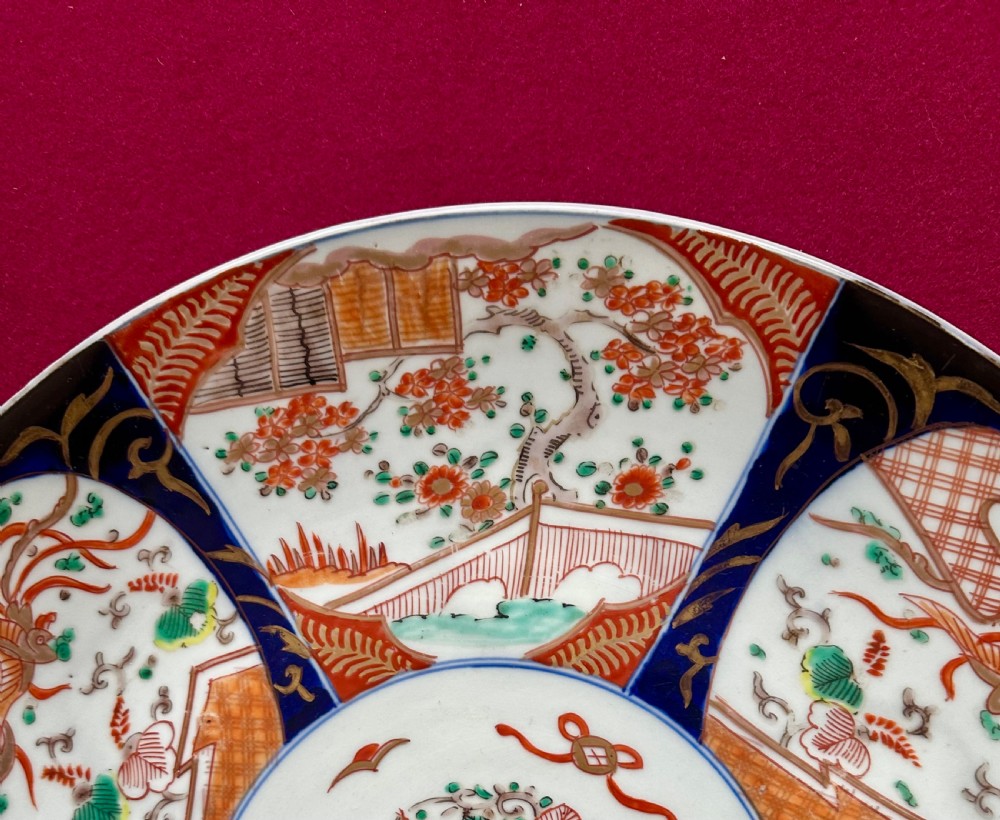 A circular Japanese Imari porcelain charger featuring cobalt blue and iron-red panelled decorations with floral motifs and phoenix figures. View III