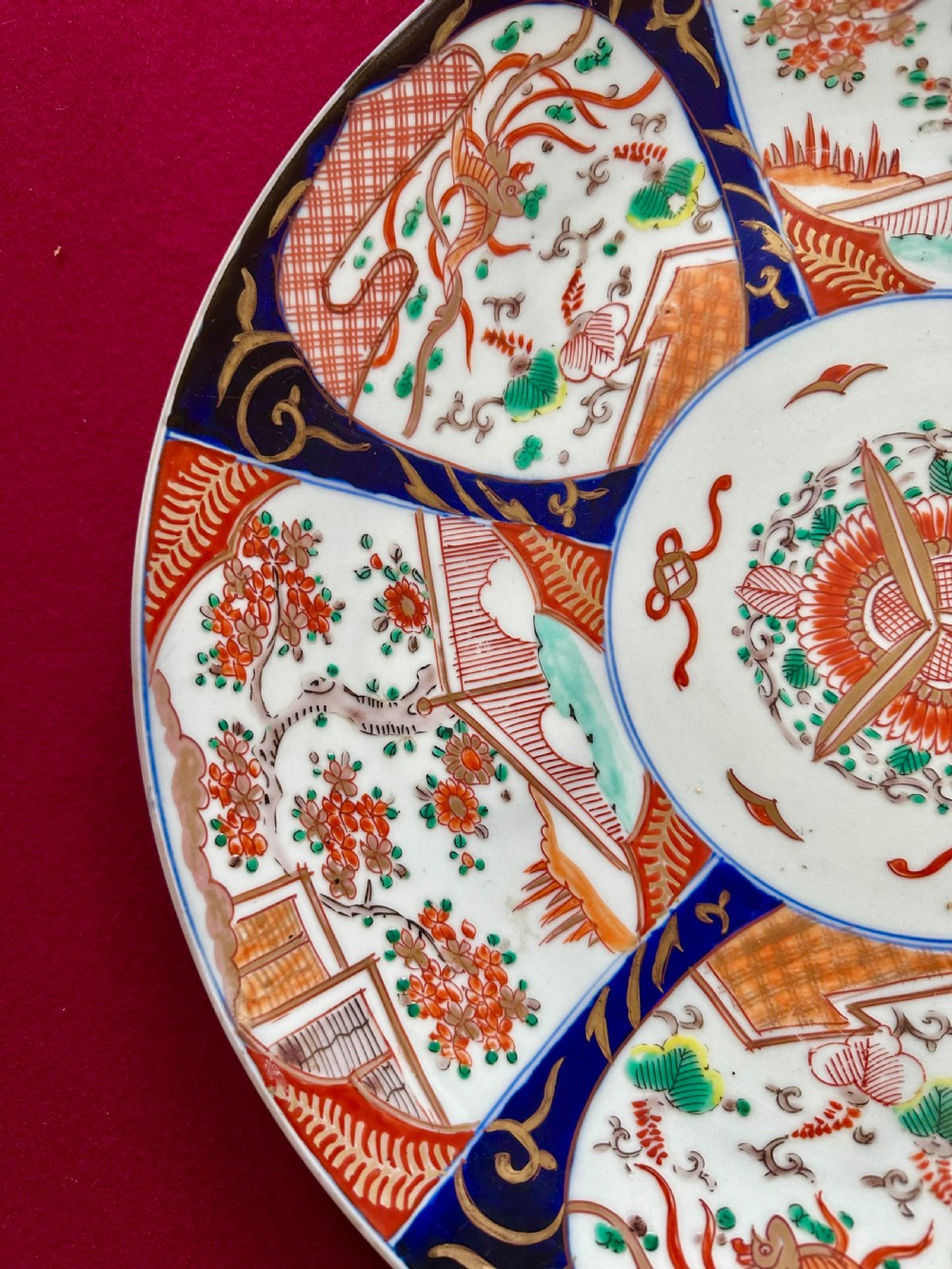 A circular Japanese Imari porcelain charger featuring cobalt blue and iron-red panelled decorations with floral motifs and phoenix figures. View VII