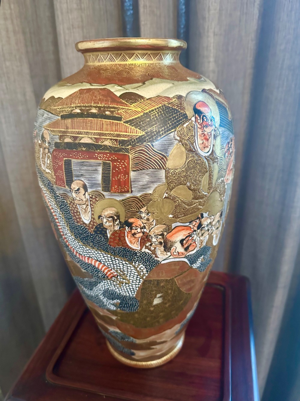 A large Japanese Satsuma earthenware vase featuring detailed hand-painted figures with halos, highlighted with heavy gold leaf accents. View V