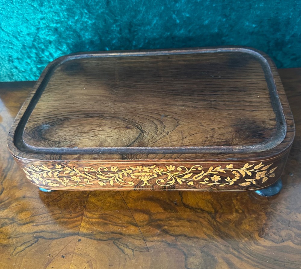 A tall arched clear glass display dome resting on a rectangular wooden base featuring floral marquetry inlay and small bun feet. View III