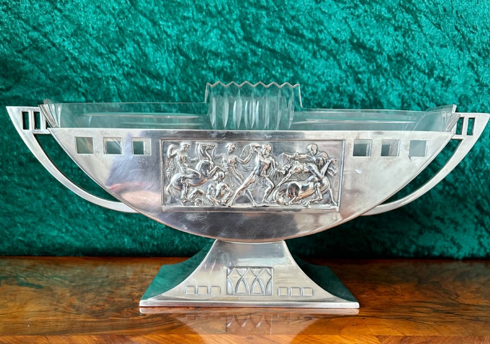 An Art Deco silver-plated boat-shaped tazza with a central classical relief panel and a fitted cut glass liner. View II