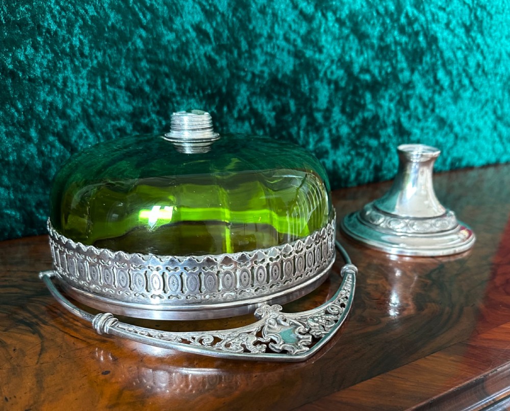 An Art Nouveau silver-plated pedestal basket featuring an ornate swing handle, pierced filigree decorative band, and a green glass liner. View VII