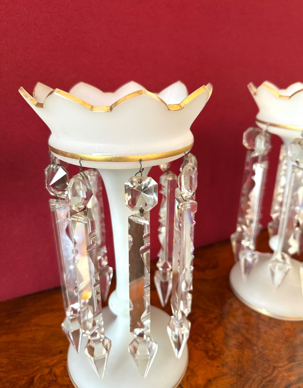 A pair of Victorian frosted white glass lustres featuring crenellated gilt-rimmed tops and suspended clear cut-crystal spearhead prisms. View V