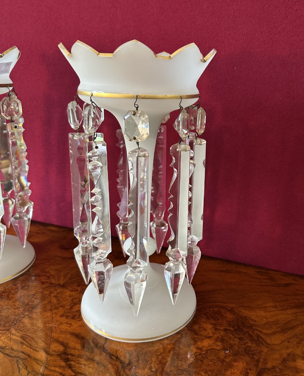 A pair of Victorian frosted white glass lustres featuring crenellated gilt-rimmed tops and suspended clear cut-crystal spearhead prisms. View VI