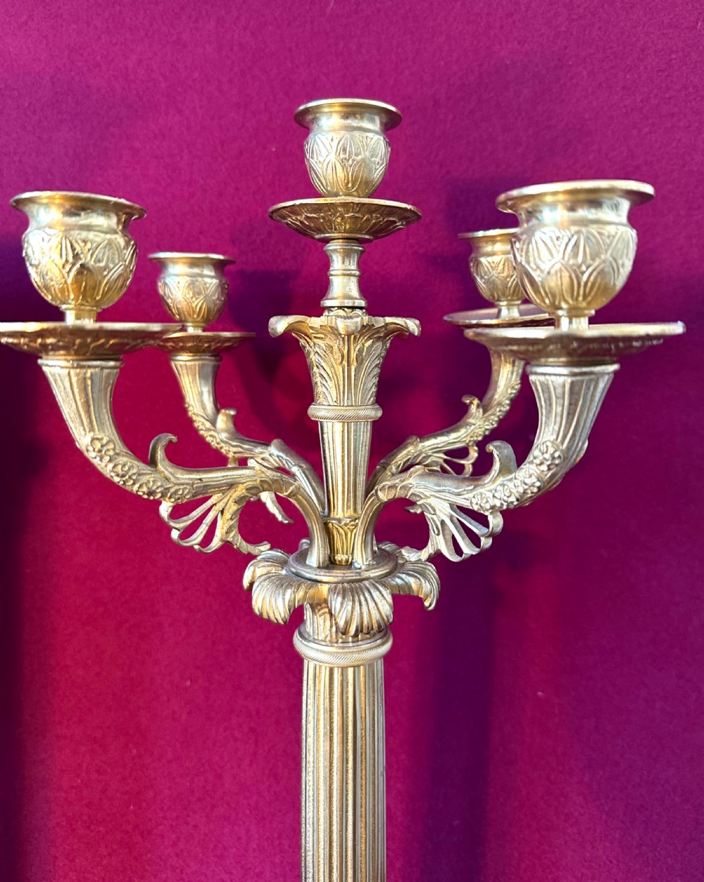 A 19th-century French clock garniture featuring a central portico-style green onyx mantel clock with gilt-bronze mounts flanked by two matching five-light candelabra. View VII