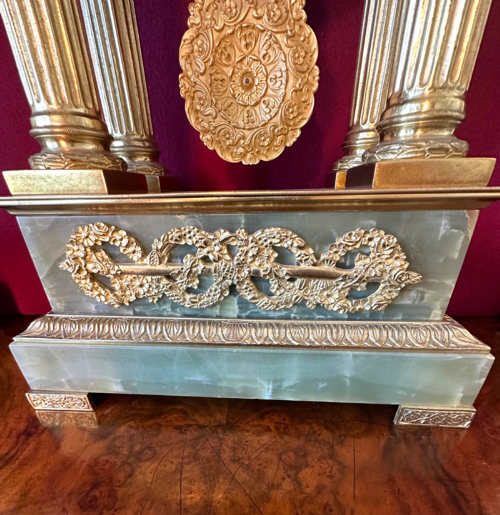 A 19th-century French clock garniture featuring a central portico-style green onyx mantel clock with gilt-bronze mounts flanked by two matching five-light candelabra. View IX