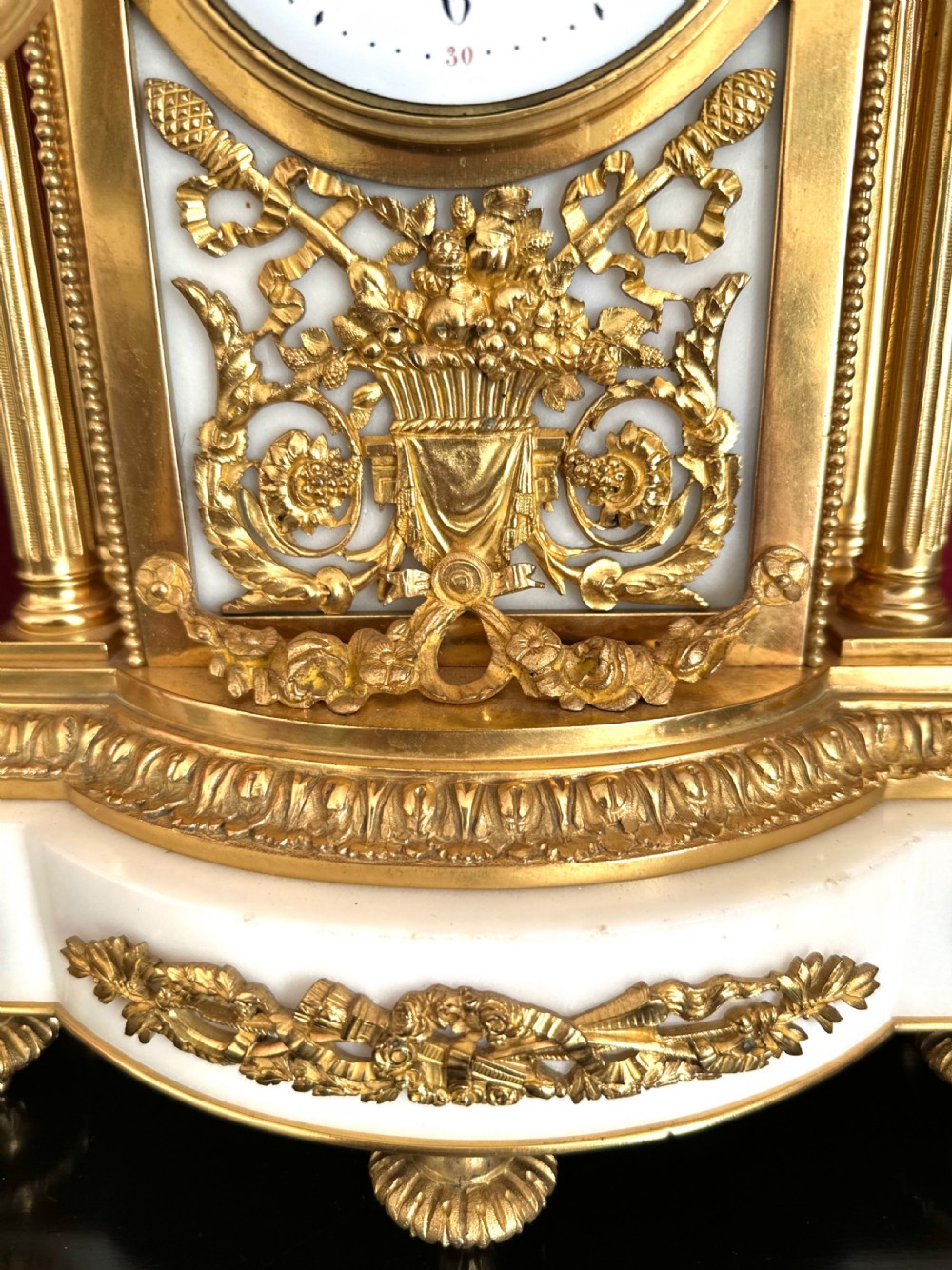 A late nineteenth-century French Louis XVI revival mantel clock made of gilt ormolu and white marble, featuring putti figures flanking a white enamel dial. View III