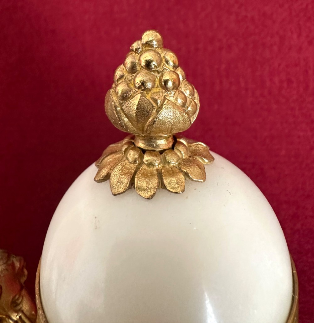 A late nineteenth-century French Louis XVI revival mantel clock made of gilt ormolu and white marble, featuring putti figures flanking a white enamel dial. View XIII