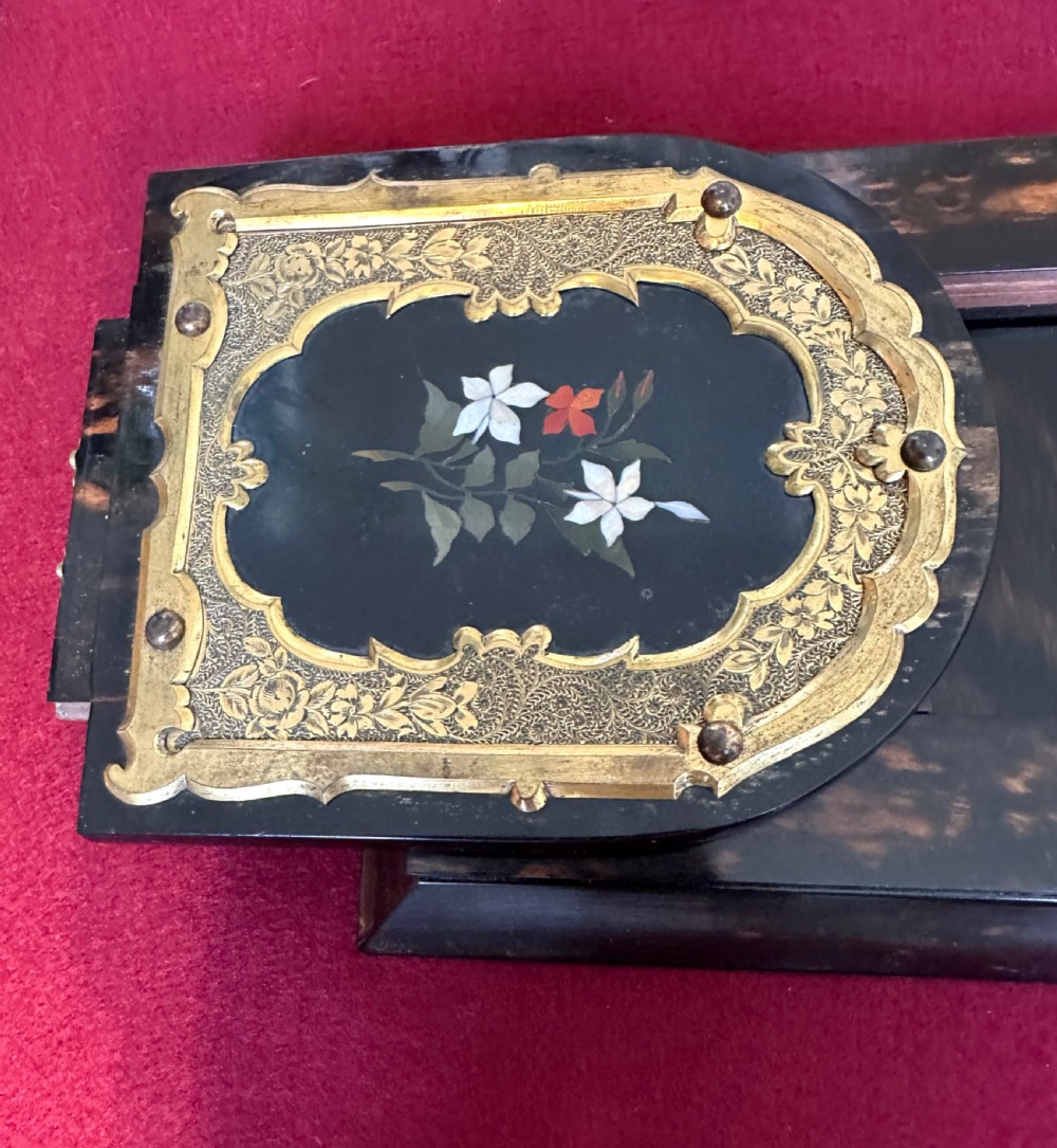 An expanding Victorian desk book slide crafted from dark coromandel wood, featuring hinged arch-shaped ends set with pietra dura floral stone inlays surrounded by engraved brass mounts. View III