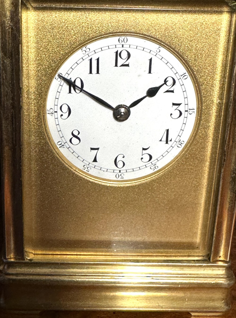 An antique brass repeating carriage clock featuring a top carrying handle, four bevelled glass panels, and a white circular dial with Arabic numerals. View IV