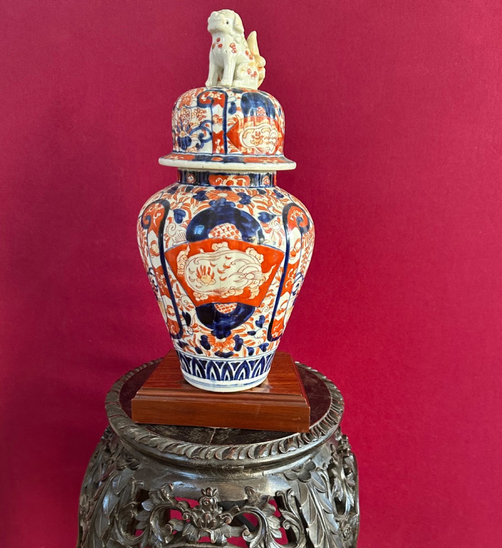 Japanese Imari porcelain covered vase featuring cobalt blue and iron red floral patterns with a shishi lion finial on the lid.