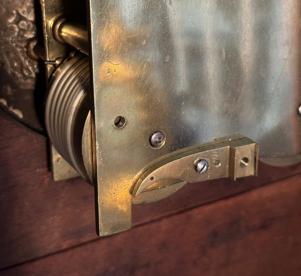 A Georgian mahogany bracket clock featuring brass inlay, lion mask handles, a top brass finial, and a circular dial signed Thos Marsh Dorking. View VI