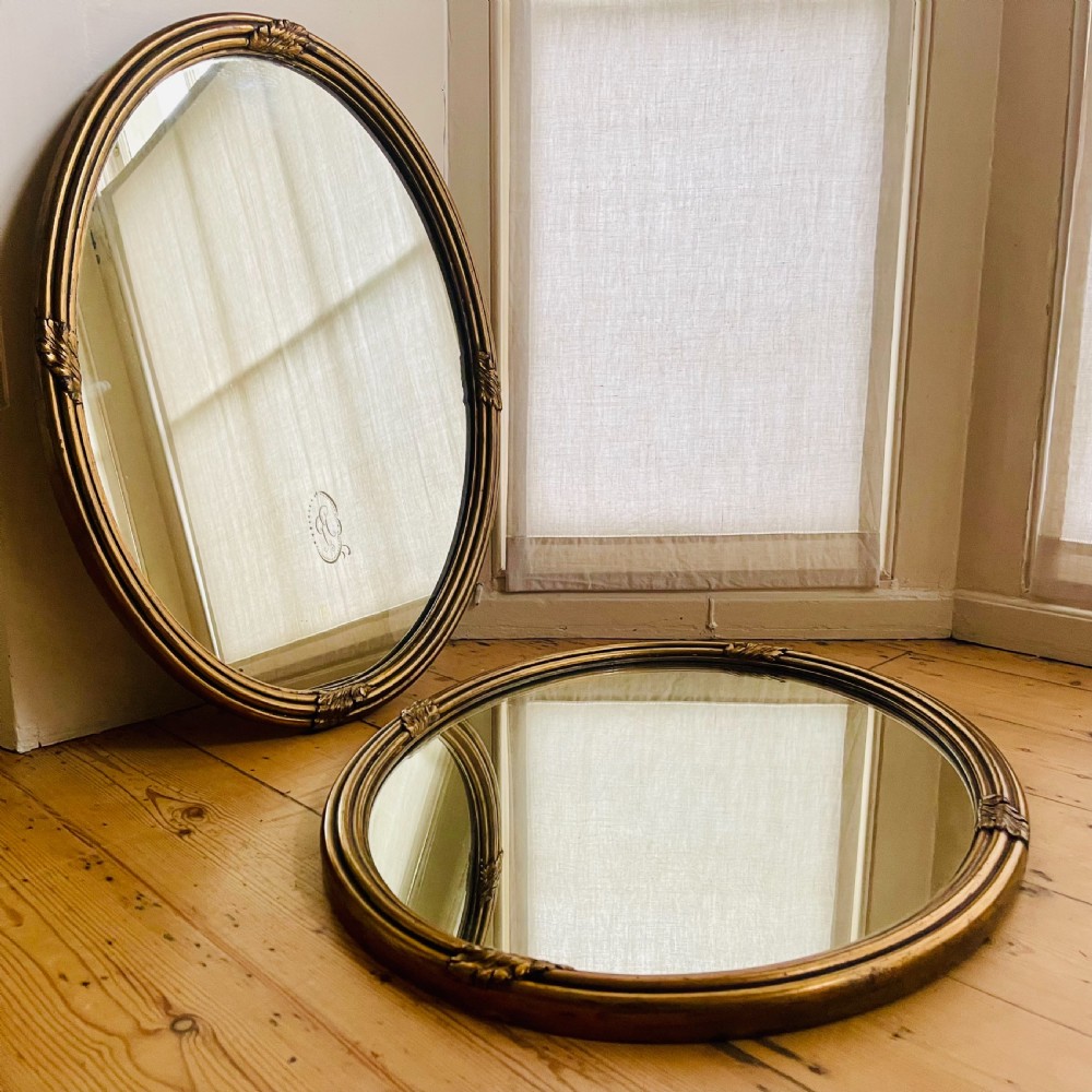 Pair of antique gilt oval mirrors
