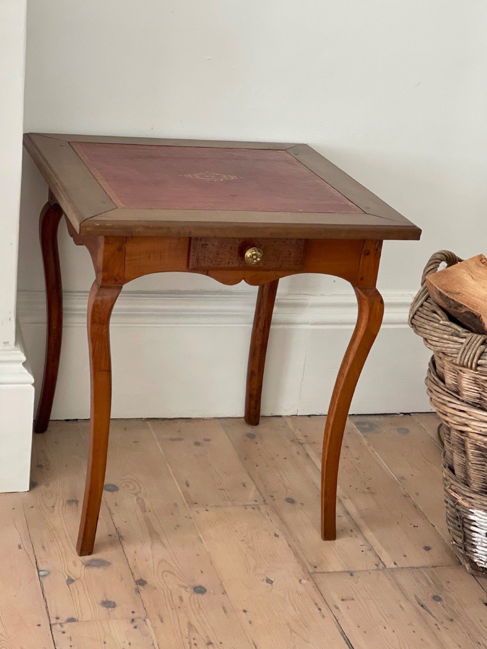 An antique French side table featuring a warm brown leather inset top, slender cabriole legs, and a single drawer with a brass knob. View IV